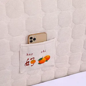Detail view of thickened quilted headboard cover pocket texture and cozy beige fabric.