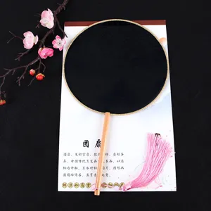 Black traditional Chinese round fan with wooden handle and delicate pink tassel detail.