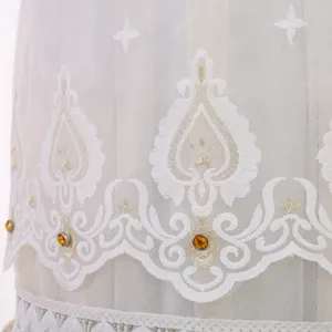 Squisito dettaglio di copertura antipolvere per condizionatore verticale in pizzo bianco.