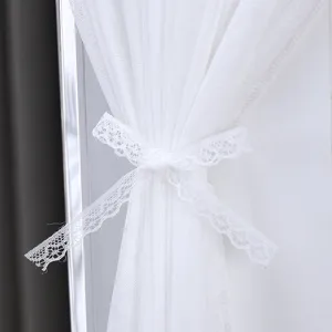 White lace tie detail for sheer curtain or dust cover, elegant home textile accessory.