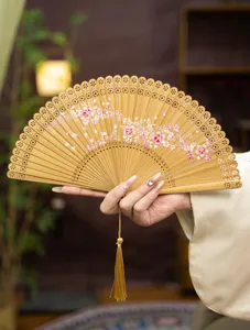 Close-up of wooden folding fan detail, featuring delicate hollow-carved patterns and sakura.