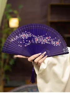 Detailed view of traditional Chinese bamboo folding fan with delicate hollow carved cherry blossom.