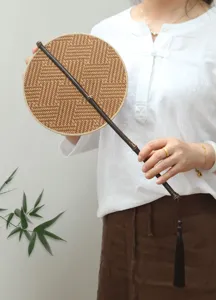 Detailed shot of a handcrafted woven bamboo round fan featuring an elegant dark bamboo handle.