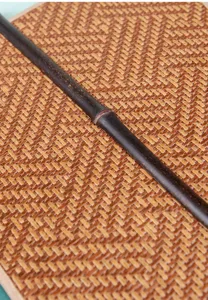Close-up detail of the natural purple bamboo handle and woven texture of the traditional hand fan.