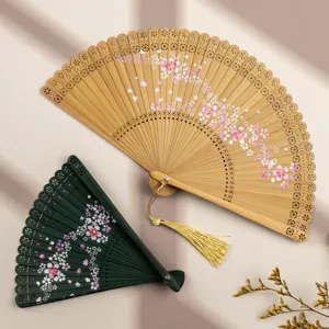Chinese style bamboo folding fan with hollow carved design and cherry blossom print for summer.