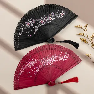 Chinese style bamboo folding fan set with carved hollow cherry blossom pattern and delicate tassel.