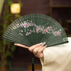 Traditional Chinese bamboo folding fan with delicate hollow carved cherry blossom patterns.