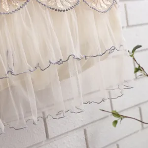 Detailed shot of beige lace air conditioner dust cover with delicate floral embroidery.