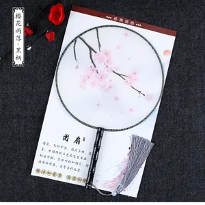 Detail shot of traditional Chinese round fan, translucent fan surface with pink cherry blossoms.