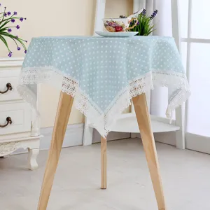 Detailed view of light blue polka dot cotton linen tablecloth with white lace.
