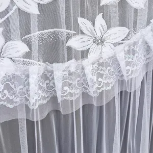 White lace TV dust cover detail showing delicate floral pattern and elegant ruffle trim.