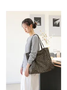 Stijlvolle vrouw met een vintage canvas tote bag met luipaardprint in een kamer