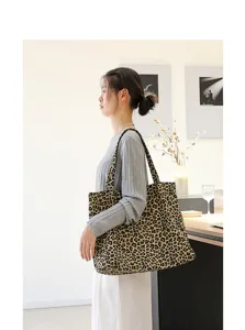Model toont de grootte van een canvas draagtas met luipaardprint in een setting.