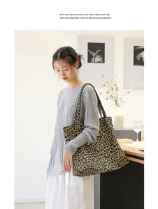 Modieuze vrouw die een grote canvas draagtas met luipaardprint draagt in een minimalistisch huis