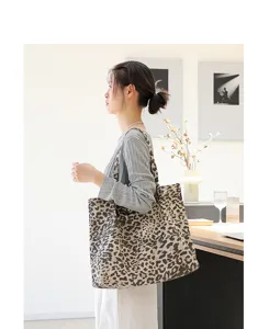 Vrouw met een stijlvolle grote canvas draagtas met luipaardprint in een lichte kamer