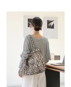 Stijlvolle retro canvas draagtas met luipaardprint gedragen door een vrouwelijk model