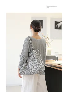 Gedetailleerd achteraanzicht van een stijlvolle canvas tote bag met panterprint op model