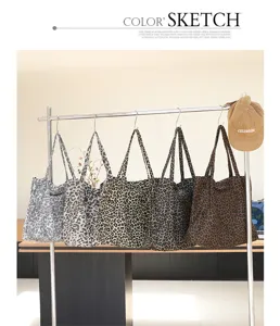 Selectie vintage canvas draagtassen met luipaardprint in diverse tinten aan een rek