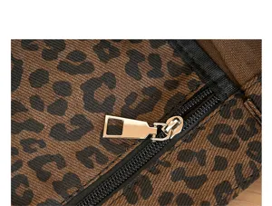 Detailopname van een gouden metalen rits op een canvas tas met retro luipaardprint
