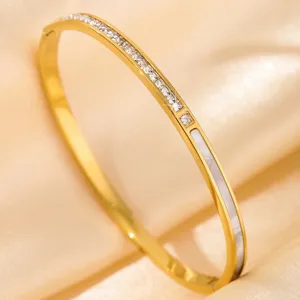 Gold titanium steel bangle close-up, featuring sparkling crystal stones and sleek white inlay.