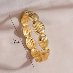 Close-up of golden segmented ridged metal bangle showcasing texture and buckle clasp detail.