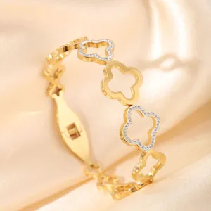 Detailed view of gold titanium steel clover bracelet, featuring rhinestone paved hollow flowers.