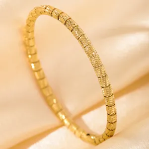 Gold-tone segmented bangle bracelet detail view, showcasing vintage fashion jewelry design.