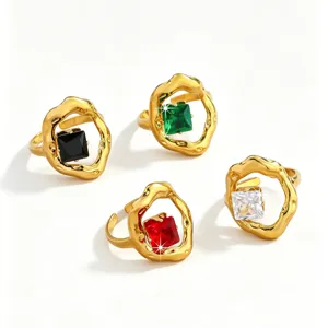 Close-up detail of chunky irregular gold rings featuring square colorful cubic zirconia stones.