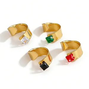 Closeup view of chunky gold-plated open rings set with square colored cubic zirconia stones.