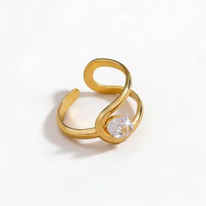 Detailed view of a gold open ring with a sparkling clear zircon and elegant curved design.
