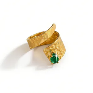 Detailed view of French vintage gold stainless steel hammered wrap ring with green zircon.
