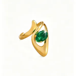 Close-up detail of the elegant gold asymmetrical ring with sparkling green stone embellishment.
