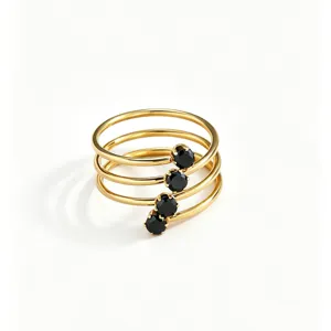 Detailed close-up of a multi-loop spiral gold ring featuring sparkling black zirconia stones.