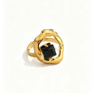 Close-up detail of the irregular molten gold ring featuring a central square black zircon.