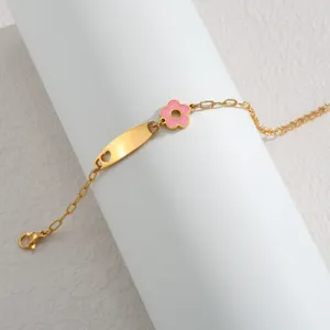 Goldfarbenes Edelstahlarmband Detail mit rosa Oeltropfenblume und blankem gebogenem Schild.