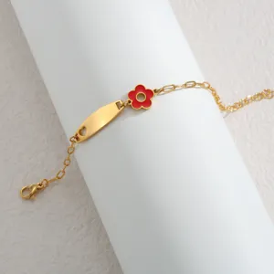 Goldfarbenes Edelstahl Armband mit rotem Emaile Blumenanhang und gravierbarem ID Plättchen.