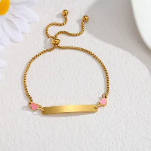 Stainless steel gold plated ID bar bracelet detail, adjustable chain with pink heart charms closeup.