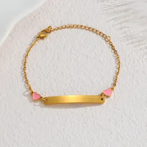 Gold stainless steel ID bracelet detail showing pink enamel hearts and curved blank plate.