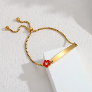 Edelstahl Gold Armband mit glatter gebogener Plakette und roter Emaille Blüte Charm.