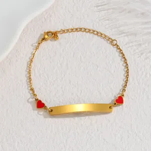 Gold stainless steel curved ID plate bracelet featuring red heart charms, minimalist jewelry.