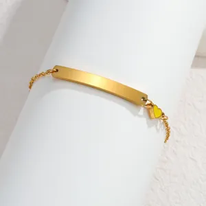 Goldfarbenes Edelstahlarmband mit gebogener Platte und gelbem Emaile-Herzanhänger chic