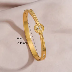 Gold stainless steel open cuff bracelet with central crystal round motif, 6cm diameter size.
