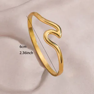 Close-up detail of the elegant gold-plated wave stainless steel open bangle bracelet.