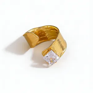 Detailed view of wide gold plated textured cuff ring with sparkling square crystal stone.