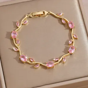 Detailed shot of gold-plated bracelet with sparkling pink cubic zirconia stones in leaf shape.