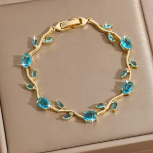 Close-up of luxury gold-plated vine bracelet featuring sparkling blue zirconia leaf stones.