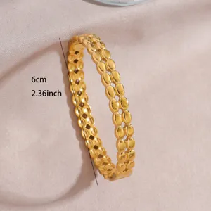 Detail shot of the gold plated stainless steel open bangle, showing the double-row textured design.