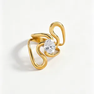 Detailed close-up of a stylish gold-plated swirl stainless steel ring with a sparkling oval zircon centerpiece.