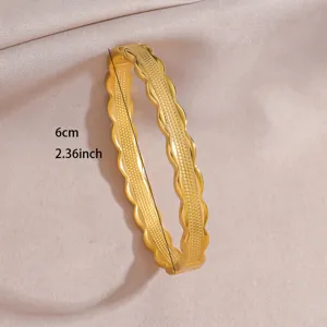 Gold plated stainless steel open bangle bracelet with wavy geometric design for women detail view.