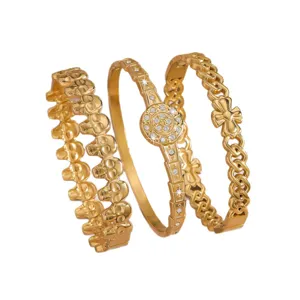Gold stainless steel stackable bangles set featuring skull, crystal medallion, and cross links.